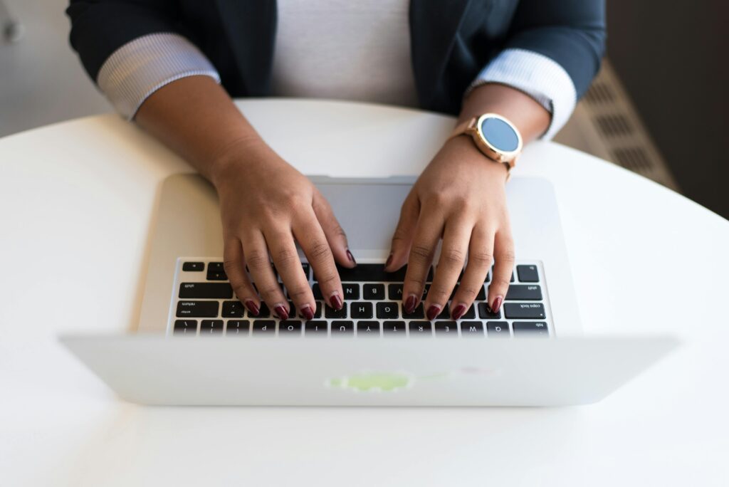 pexels-photo-1181441-1181441 Woman's hands typing on a wireless laptop at a modern office desk, highlighting technology in business.